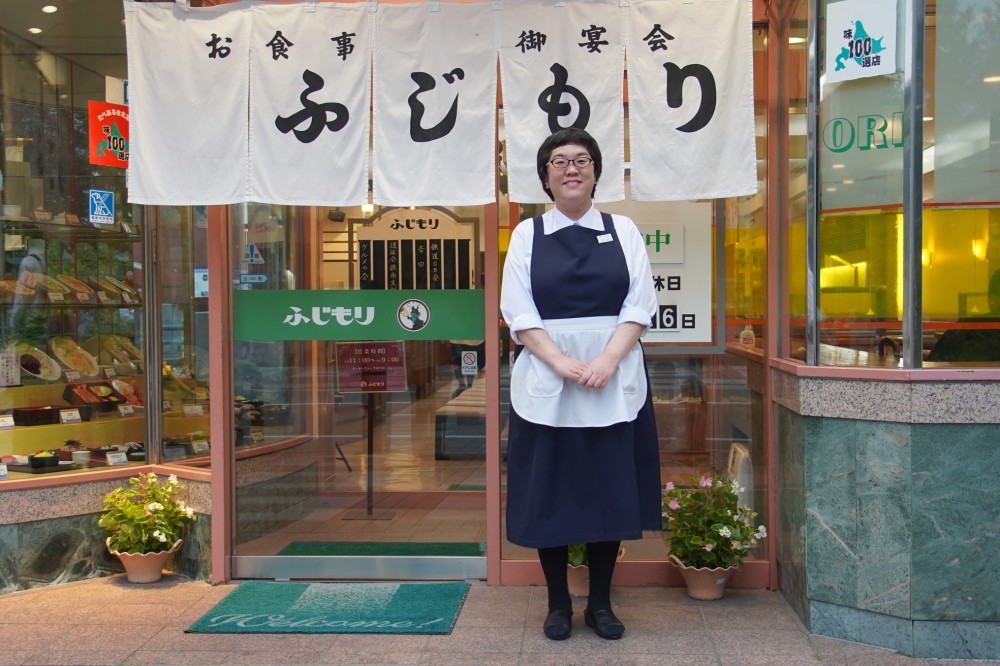 ふじもり本店のスタッフの米谷さんは、ホールで接客や配膳、後片付け、レジ打ちなどを担当。「約120年にわたる歴史の中で、自分がこの歴史の一部として働いていると思うと、不思議な感動が湧き上がってきます。帯広の皆様から愛される名店で、あなたも一緒に働いてみませんか」。